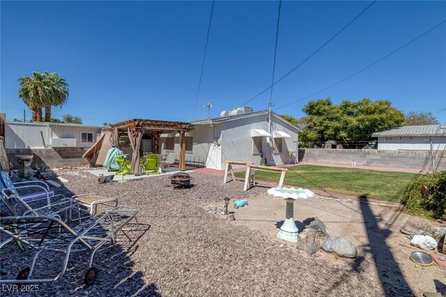 back of house featuring a yard and an outdoor fire pit