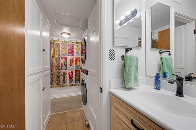 bathroom with vanity, walk in shower, tile patterned floors, and stacked washing maching and dryer