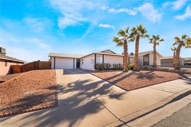 view of front of house featuring driveway, an attached garage, and fence