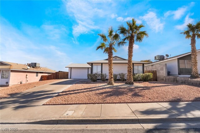 ranch-style home with a garage and cooling unit