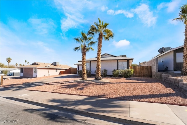 view of front of home with an attached garage, driveway, and fence