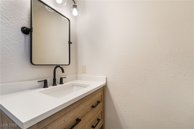 bathroom with a textured wall and vanity