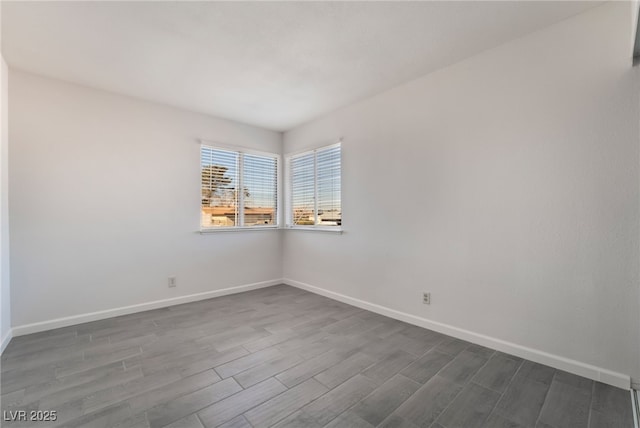 empty room featuring dark wood-style floors and baseboards