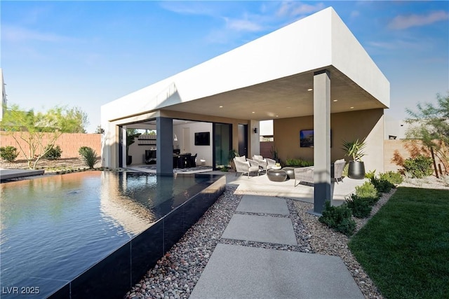 rear view of house with a fenced in pool, a patio, and an outdoor hangout area