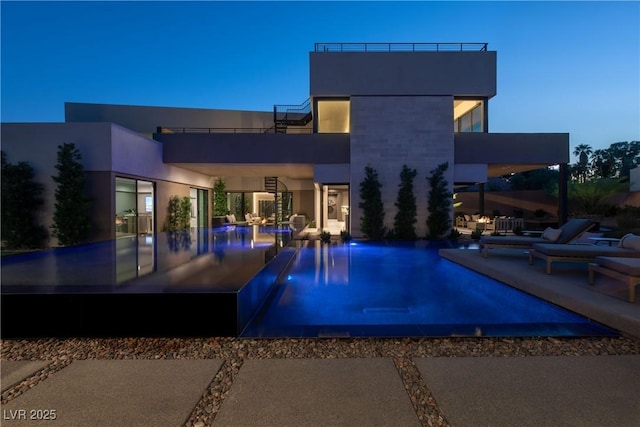 pool at dusk with a patio