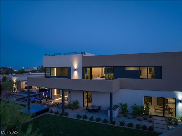 back of property featuring a patio and a balcony