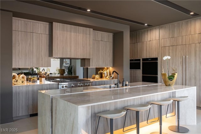 kitchen with a kitchen bar, sink, and light brown cabinets