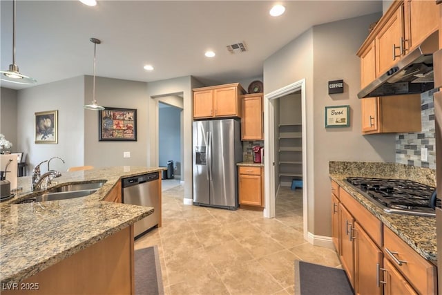 kitchen featuring appliances with stainless steel finishes, pendant lighting, sink, decorative backsplash, and light stone countertops