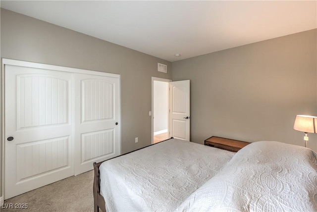 bedroom with light colored carpet and a closet