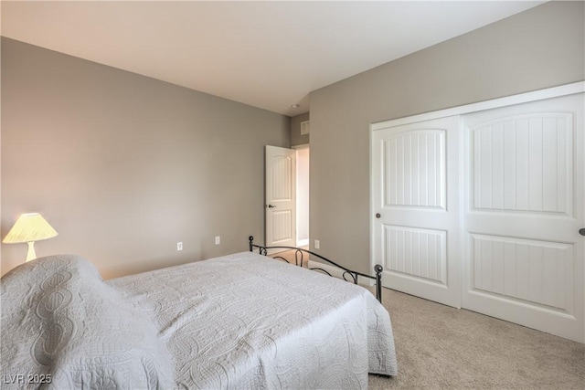 bedroom with light carpet and a closet