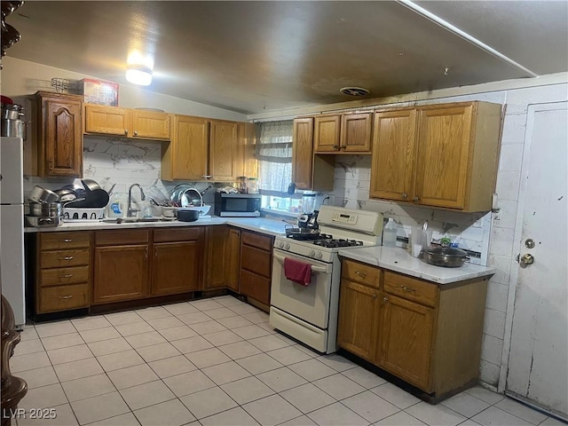 kitchen featuring tasteful backsplash, lofted ceiling, sink, and white gas range oven