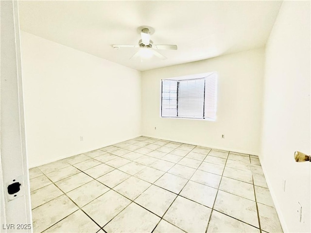 tiled spare room featuring ceiling fan