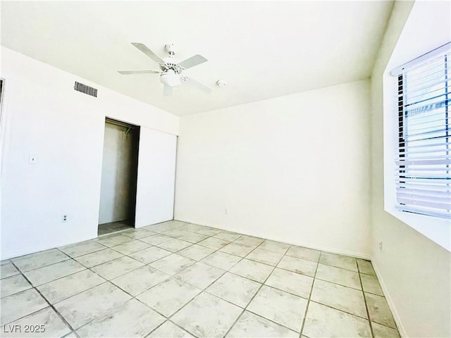 empty room with light tile patterned floors and ceiling fan