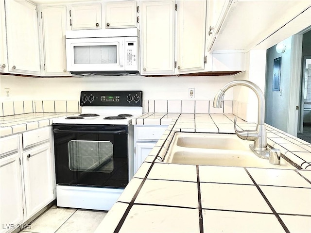 kitchen featuring range with electric cooktop, tile countertops, white cabinetry, sink, and light tile patterned floors