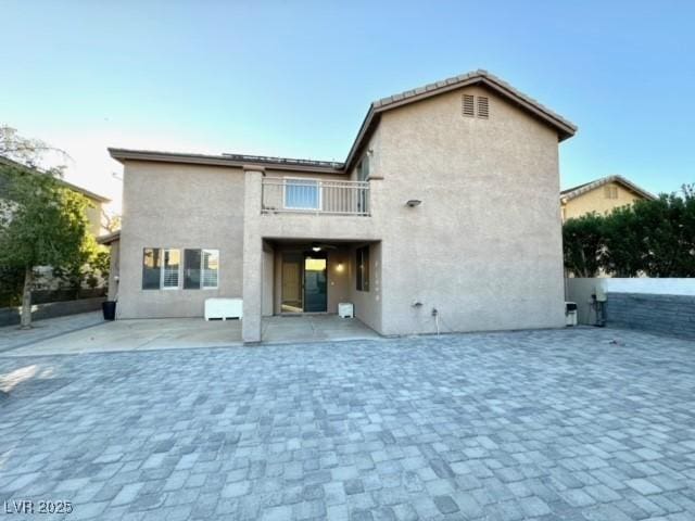 back of property featuring a patio and a balcony