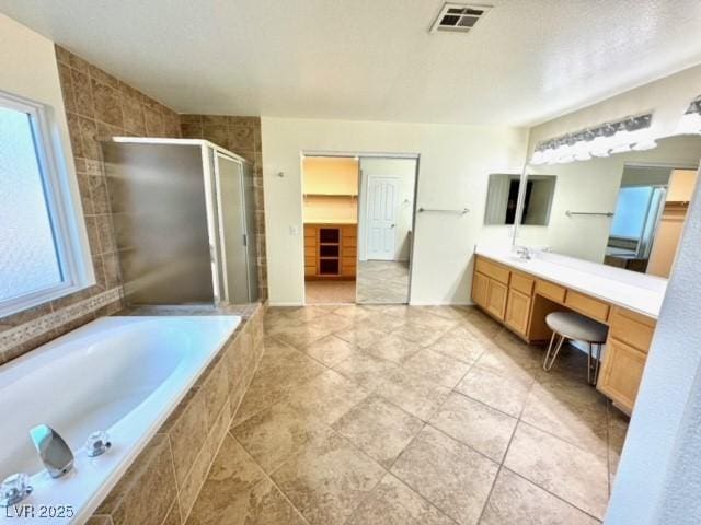 bathroom with independent shower and bath, vanity, and a wealth of natural light