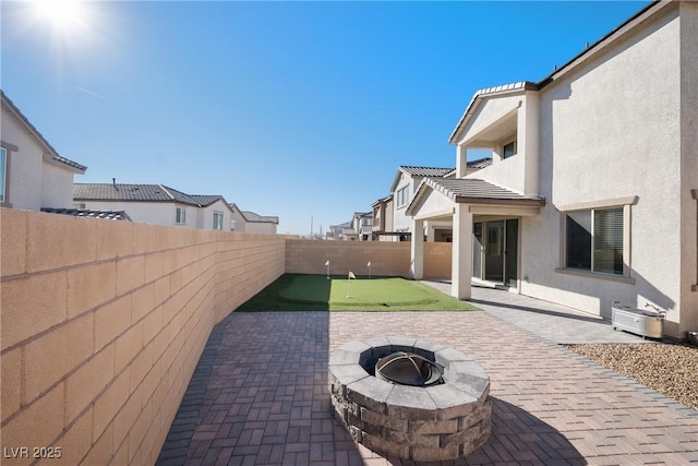 view of patio featuring a fire pit, a fenced backyard, and a residential view