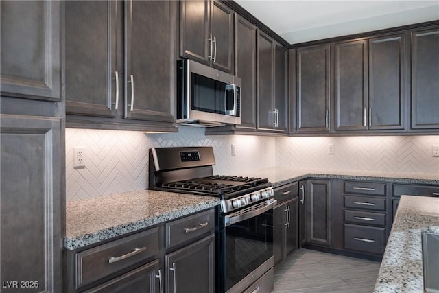 kitchen with stainless steel appliances, dark brown cabinetry, decorative backsplash, and light stone counters