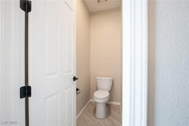 bathroom with toilet and baseboards