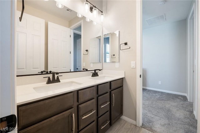 bathroom with double vanity, a sink, and baseboards