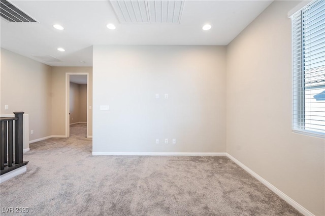 carpeted empty room with baseboards, visible vents, and recessed lighting