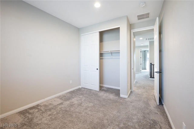 unfurnished bedroom with carpet floors, a closet, visible vents, and baseboards