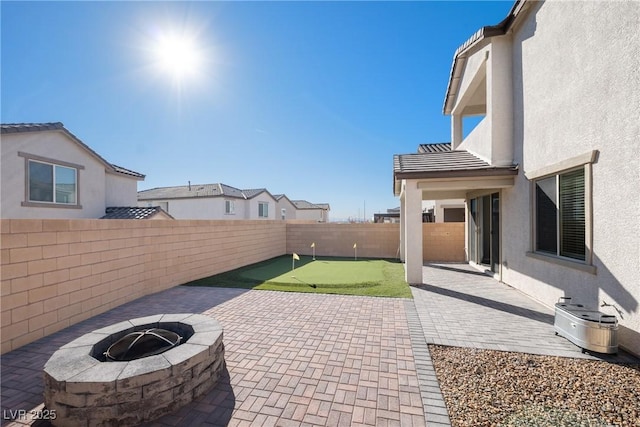 view of patio / terrace with a fenced backyard, a fire pit, and central air condition unit