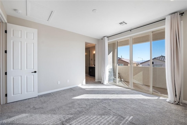 unfurnished bedroom featuring access to exterior, visible vents, attic access, carpet flooring, and baseboards