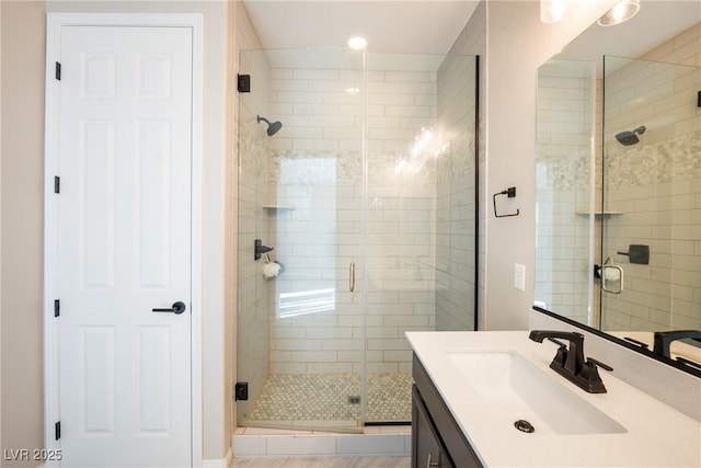 full bath with a shower stall and vanity