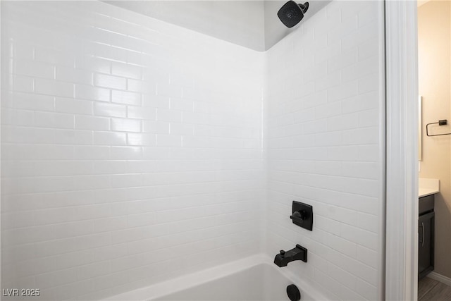 bathroom featuring washtub / shower combination and vanity