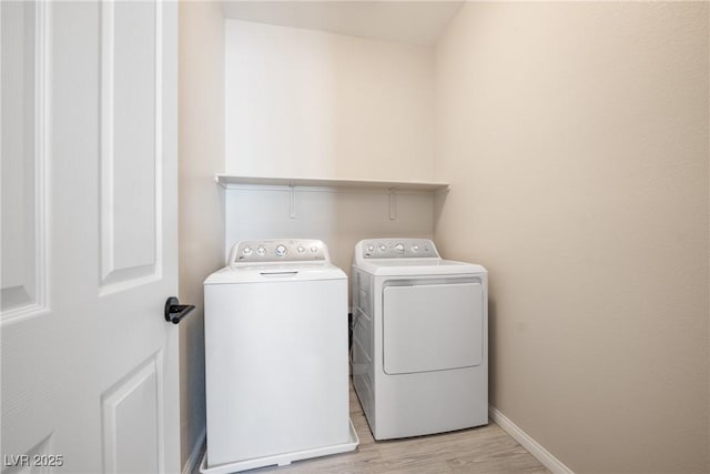 laundry area featuring light wood-type flooring, laundry area, baseboards, and independent washer and dryer