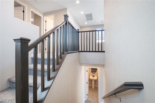 staircase with visible vents and recessed lighting