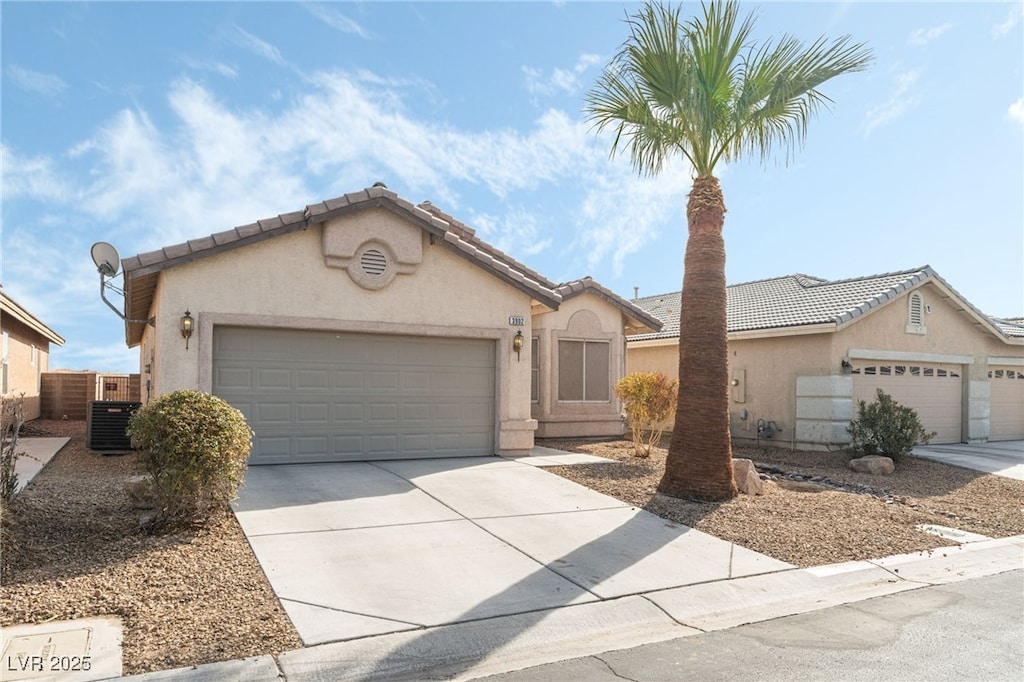 single story home with central AC unit and a garage