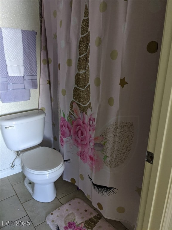 bathroom featuring tile patterned flooring, curtained shower, and toilet