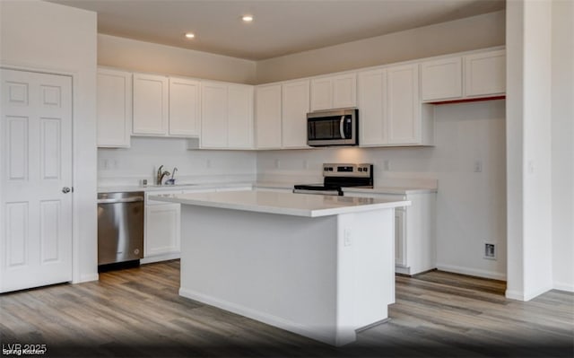 kitchen with white cabinetry, stainless steel appliances, and a center island