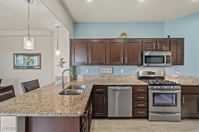 kitchen with a kitchen bar, sink, kitchen peninsula, and appliances with stainless steel finishes