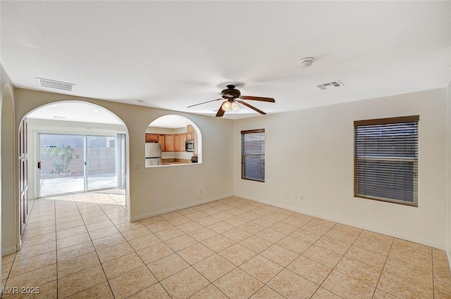 tiled spare room with ceiling fan