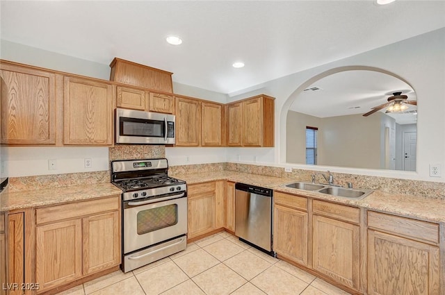 kitchen with appliances with stainless steel finishes, light brown cabinetry, sink, and light tile patterned floors