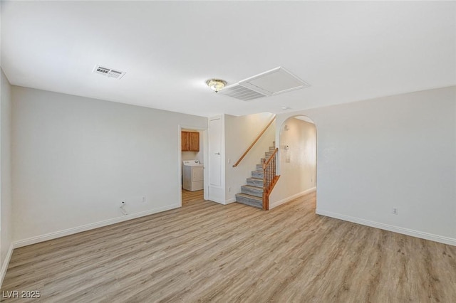 unfurnished room featuring washer / clothes dryer and light hardwood / wood-style floors