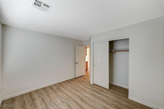 unfurnished bedroom with a closet and light hardwood / wood-style flooring