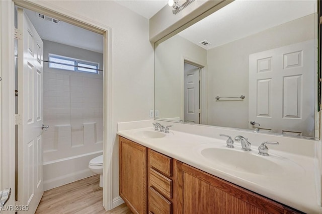 full bathroom with vanity, shower / bathing tub combination, hardwood / wood-style floors, and toilet