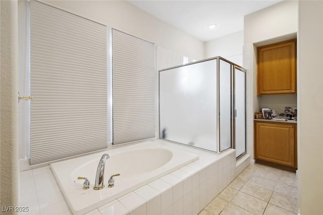 bathroom featuring a garden tub, a shower stall, and tile patterned flooring