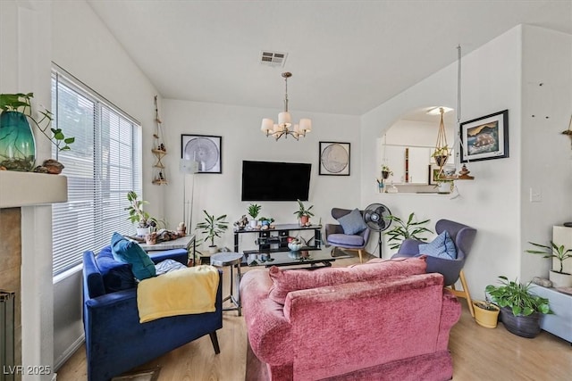 living room with an inviting chandelier and light hardwood / wood-style flooring