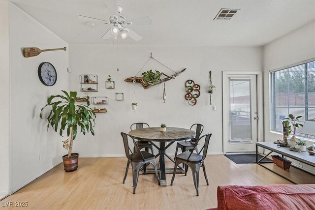 dining space with light hardwood / wood-style flooring and ceiling fan