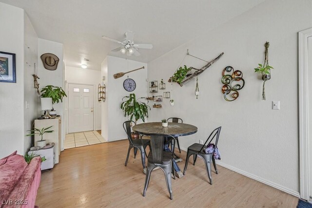 dining area with ceiling fan and light hardwood / wood-style floors