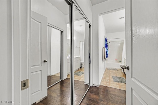 full bathroom featuring wood-type flooring, toilet, shower / bathing tub combination, and vanity