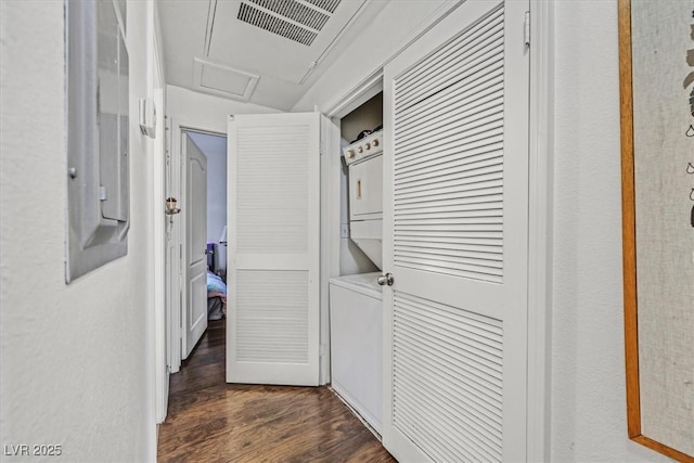 corridor with stacked washer / dryer and dark hardwood / wood-style floors