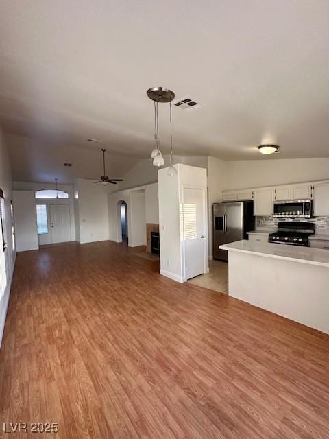 kitchen featuring appliances with stainless steel finishes, white cabinetry, hanging light fixtures, ceiling fan, and light hardwood / wood-style flooring