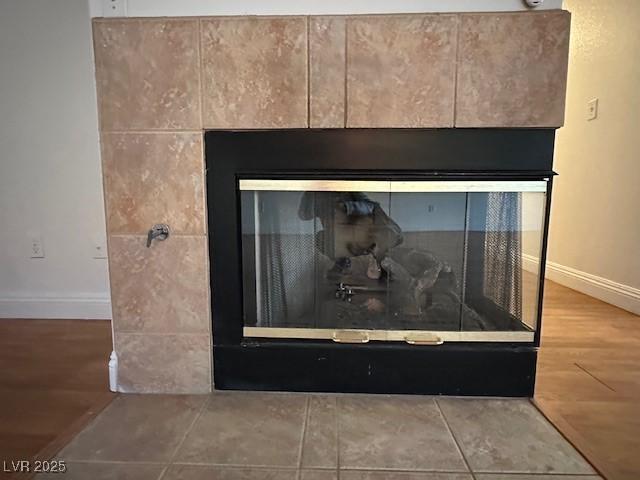 interior details with a tile fireplace and hardwood / wood-style floors