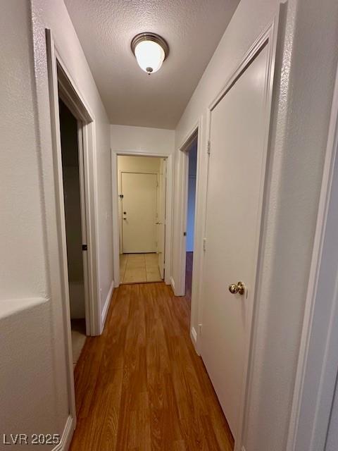 hall featuring hardwood / wood-style flooring and a textured ceiling